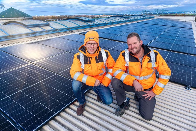 Zwei Kollegen der AWH knien vor der Anlage