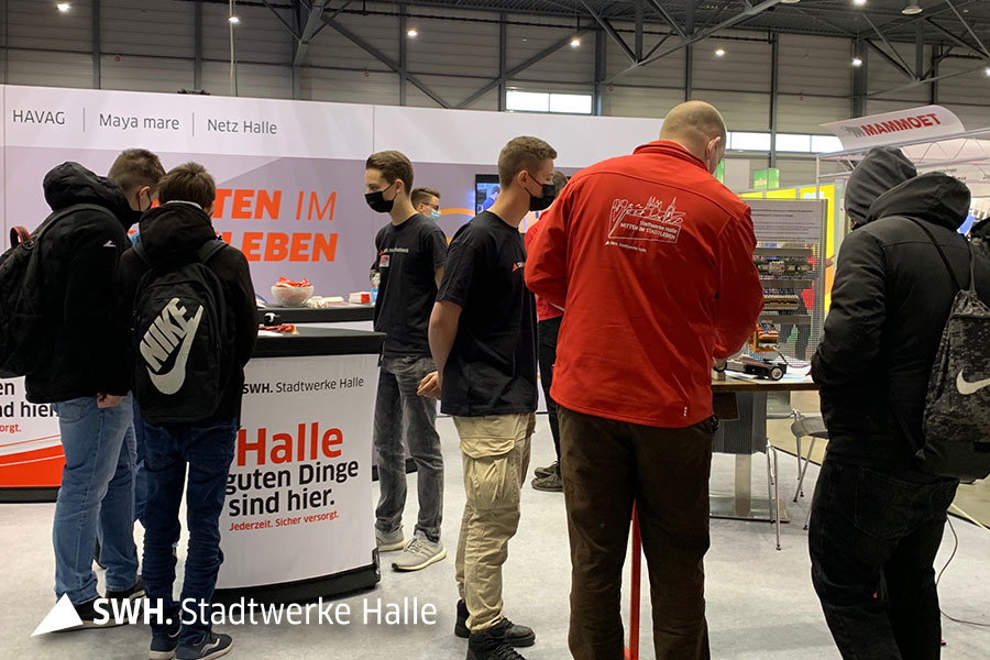 Zahlreiche Jugendliche stehen vor einem Messestand und lassen sich beraten.