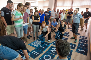 Die Miterbeiterinnen und Mitarbeiter arbeiten in teams udn stellen zum Abschluss ihre Lösungen vor. In einem interaktiven, mobilen Escape-Game namens „Beat the Box“ wurden die neuen Mitarbeiterinnen und Mitarbeiter in Teams herausgefordert, gemeinsam Aufgaben zu lösen und strategische Entscheidungen zu treffen.