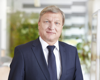 Das Bild zeigt ein Portrait von Prof. Dr. Matthias Krause. Er trägt einen dunkel-blauen Anzug, eine dunkel-blaue Krawatte und ein weißes Hemd. Er blickt freundlich in die Kamera.